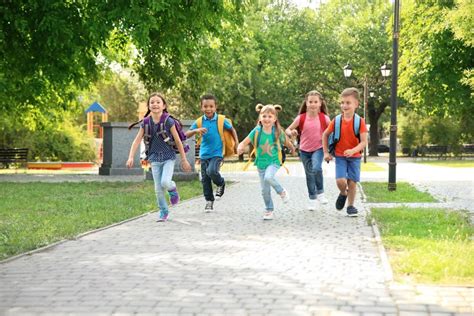 Cute Little Children With Backpacks Running Outdoors Stock Photo