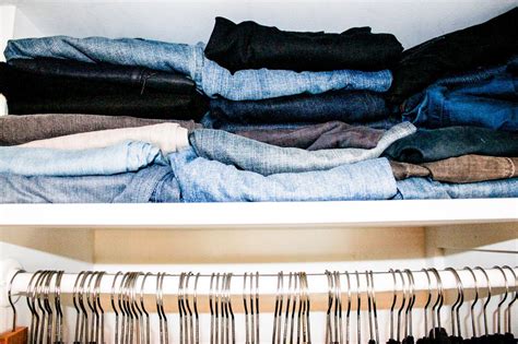 An Open Closet Filled With Clothes And Pants
