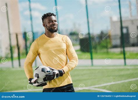 Portrait Of Smiling African American Goalkeeper Holding Ball Stock