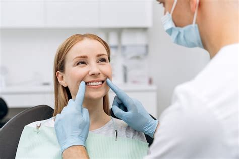 O Dentista Verifica Os Dentes De Uma Mulher Atraente O Médico Em Luvas
