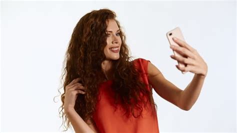 Brunette Woman Model With Curly Hair Taking A Selfie On White Background In Studio Stock Video