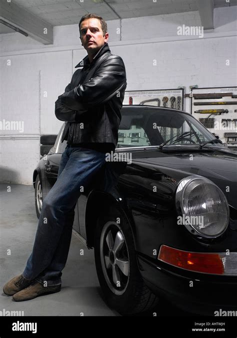Man Leaning On A Porsche In A Garage Stock Photo Royalty Free Image