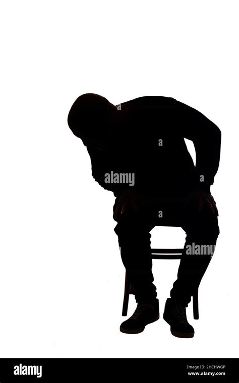 View Of The Silhouette Of A Man Sitting On Chair With Casual Clothes