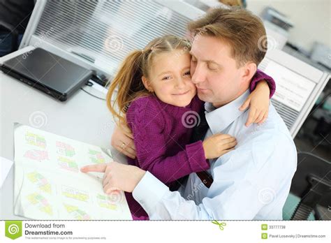 la hija feliz abraza a su padre que vea el folleto del plan del apartamento foto de archivo