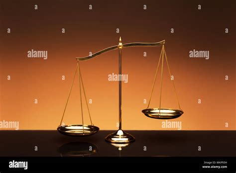 Golden Brass Balance Or Imbalance Scale On Orange Color Background