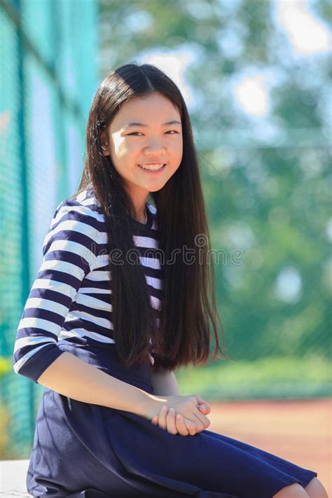 portrait happy face of asian girl toothy smiling happiness emotion in outdoor sport field stock