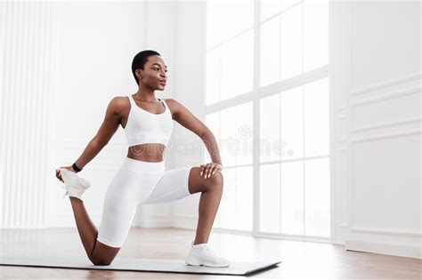 Happy Young Black Woman Stretching Leg Exercising On Yoga Mat Stock