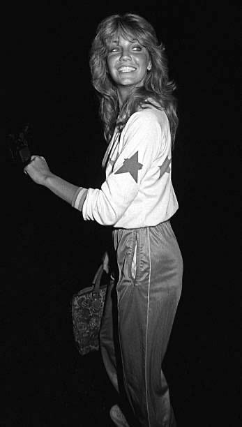 A Black And White Photo Of A Woman Holding A Handbag In Her Right Hand