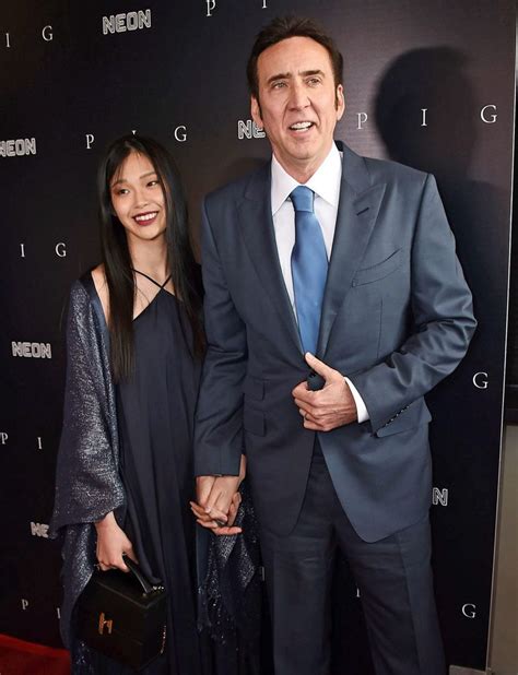 A Man In A Suit And Tie Standing Next To A Woman On A Red Carpet