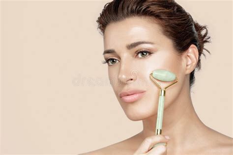 Beautiful Woman With Fresh Clean Skin Massaging Face With Jade Roller Conceptual Of Skin Care