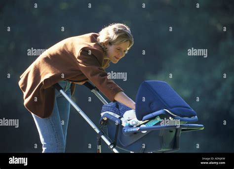 Mother Taking Her Baby For A Walk In The Buggy In The Parc Stock Photo