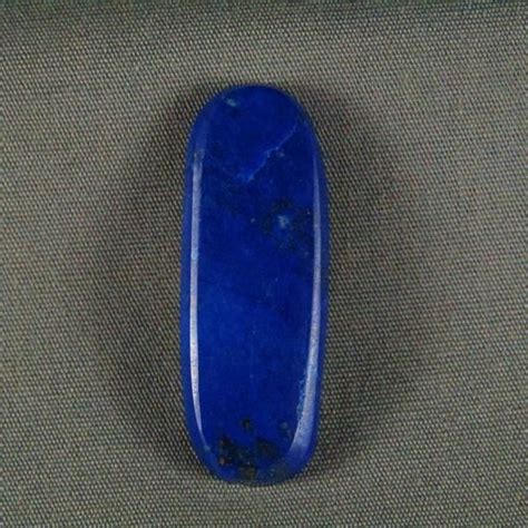 A Blue Stone Sitting On Top Of A Gray Surface Next To A Black And White