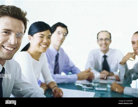 Businesspeople Sitting Around Table Smiling Stock Photo Alamy