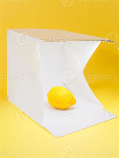 Photographer Is Shooting Lemon In The Light Cube On Yellow Background