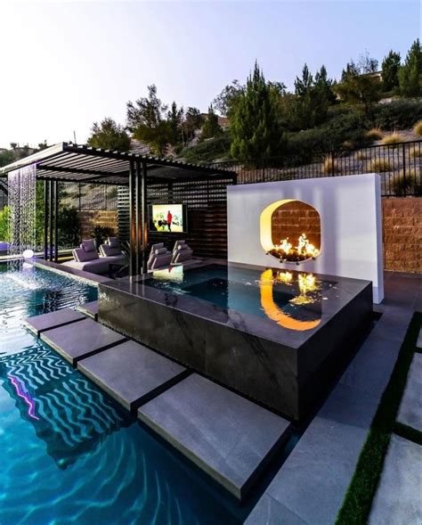 An Outdoor Fireplace In The Middle Of A Swimming Pool