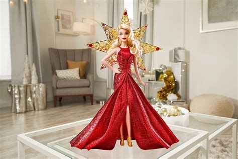 a barbie doll dressed in red and gold is standing on a glass table with christmas decorations