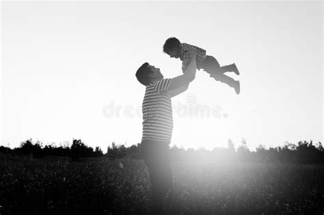 Padre E Hijo Que Juegan En El Parque En El Tiempo De La Puesta Del Sol