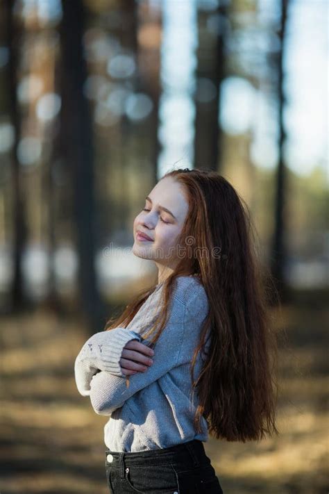 Menina Bonito De Doze Anos Com O Cabelo Vermelho Longo Que Levanta Para A C Mera No Parque Foto