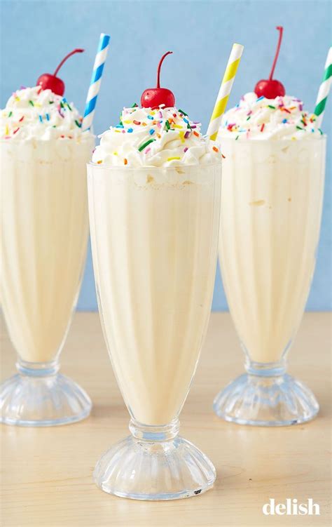 Three Glasses Filled With Whipped Cream And Topped With Sprinkles Cherries And Candy Canes
