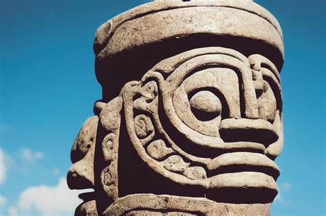 Premium Photo Stone Idols With Tiki Masks With Ornamentation Against