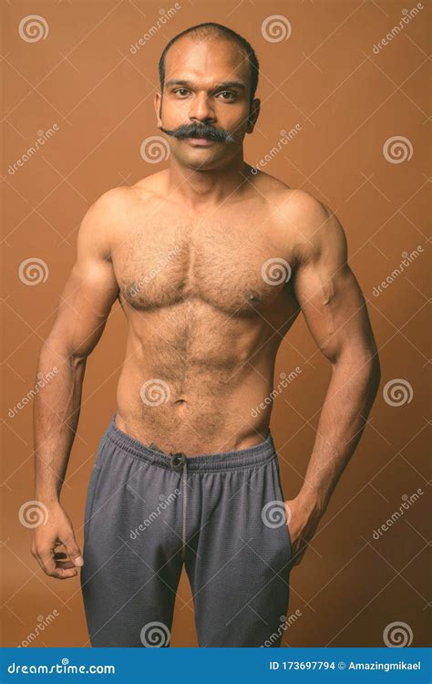 Muscular Indian Man With Mustache Shirtless Against Brown Background Stock Photo Image Of