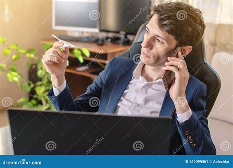 Man Businessman Holding Airline Ticket In Hand And Talking On The Phone
