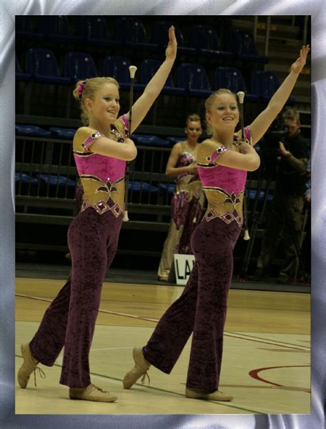 Two Women In Purple Outfits Are Dancing On A Basketball Court With