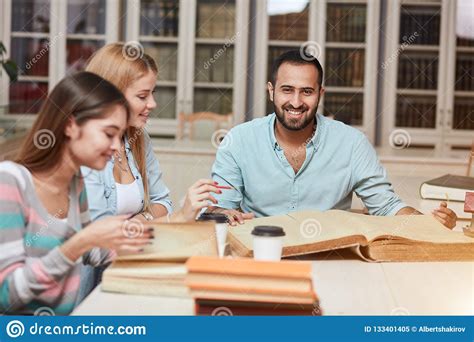 Group Of Multiracial People Studying With Books In College Library