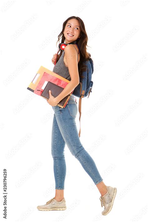 Full Length Smiling Asian College Student Walking Against Isolated