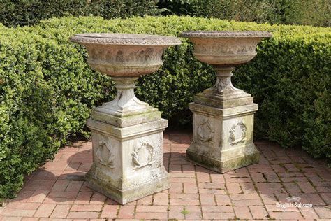 Pair Of Weathered Cast Stone Urns On Plinths