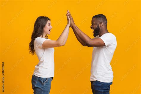 Happy Interracial Couple Giving High Five To Each Other Celebrating