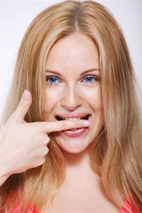 gelukkige blondevrouw die zijn vinger bijten geïsoleerd op wit stock afbeelding image of