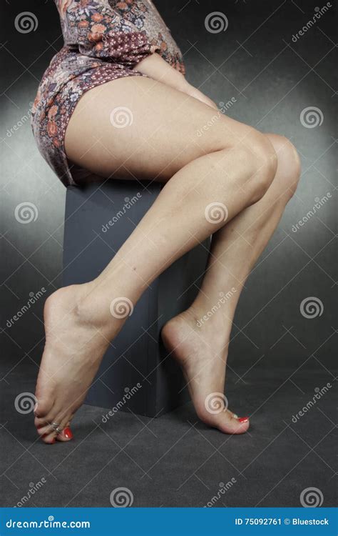 Frauenbeine Und Füße Die Mit Den Bloßen Beinen Sitzen Stockbild Bild Von Eingewachsen