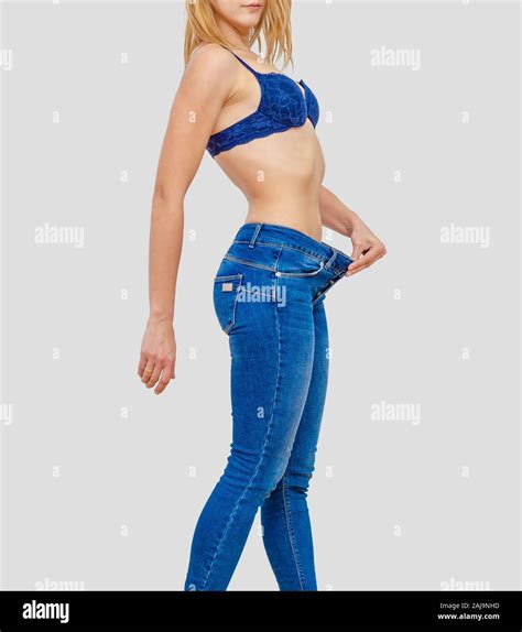 Woman Shows Weight Loss In Old Big Jeans Stock Photo Alamy