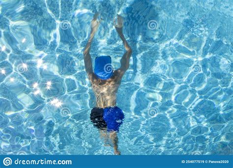 The Boy Swims Underwater In The Pool An Athlete In Swimming Goggles Is