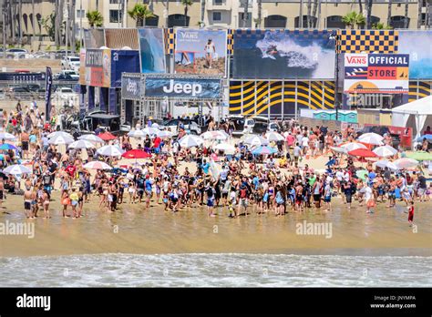 Huntington Beach, USA. 30 July, 2017. Crowds surround and carry surfer