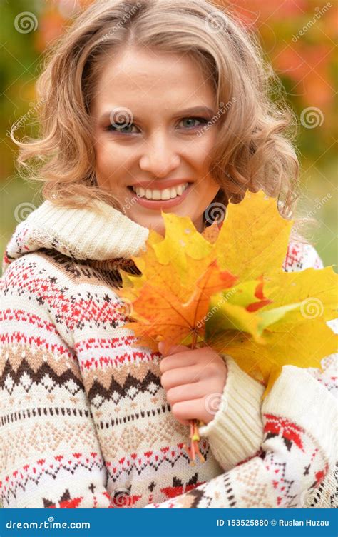 Portrait Of Beautiful Young Woman Holding Autumn Leaves Stock Photo