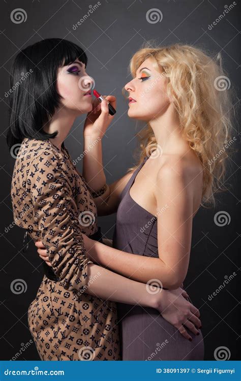 twee jonge aantrekkelijke lesbiennes koesteren met een lippenstift stock afbeelding image of