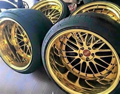 Some Gold Rims And Tires Are Stacked On Top Of Each Other In A Row