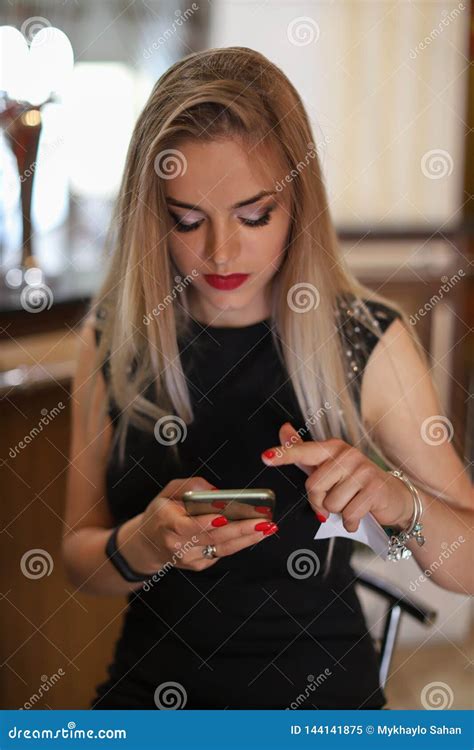 Giovane Bella Donna Bionda Che Scrive O Che Legge I Messaggi Degli Sms Online Su Uno Smart Phone