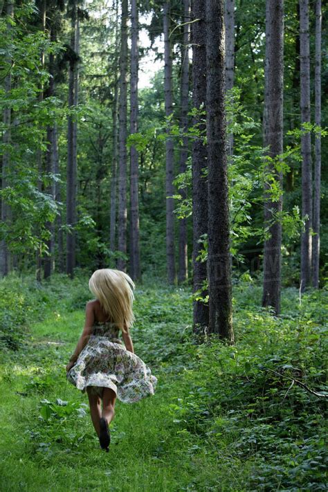 Young Woman Running Through Forest Stock Photo Dissolve
