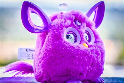 A Pink Stuffed Animal With Big Eyes And Large Ears Sitting On Top Of A