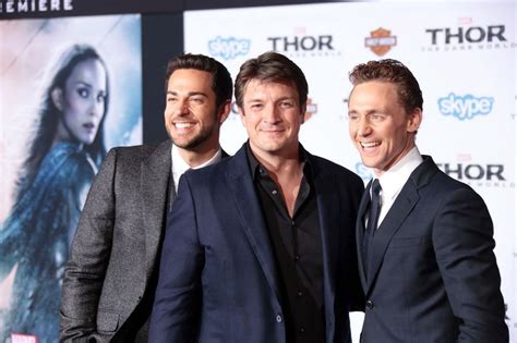 Three Men Standing Next To Each Other In Front Of A Movie Poster At An Event