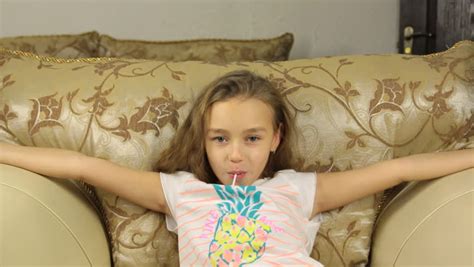 girl licking candy on a stick in the form of lemon and raises the thumbs up stock footage video