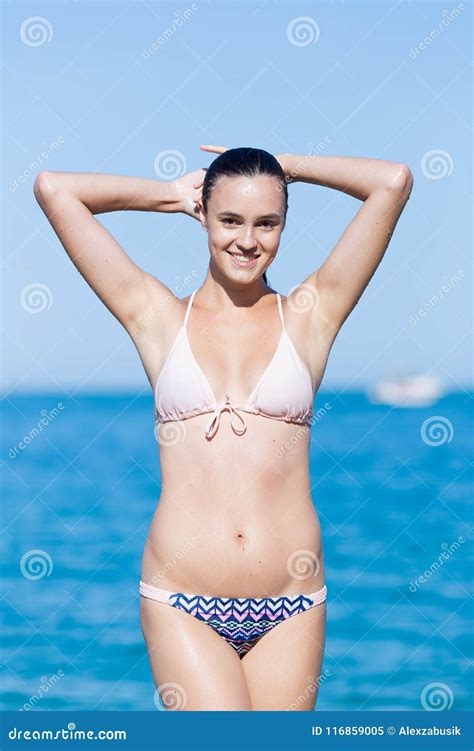 Natte Jonge Vrouw In Bikini Het Stellen In Water Stock Afbeelding
