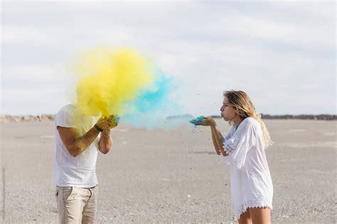 couple throwing colored powder at each other for fun del colaborador de stocksy michela