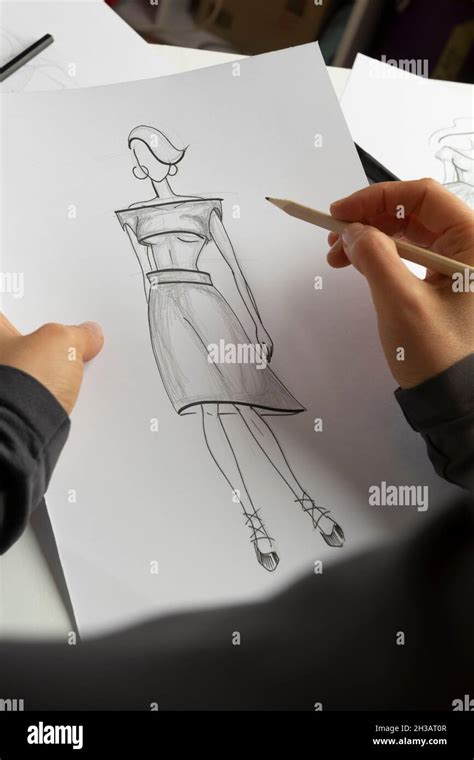 The Designer Draws Sketches Of Womens Dresses On Paper Stock Photo Alamy