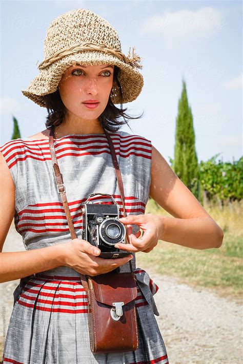 old fashioned woman with a retro camera in the italian countrysi by stocksy contributor