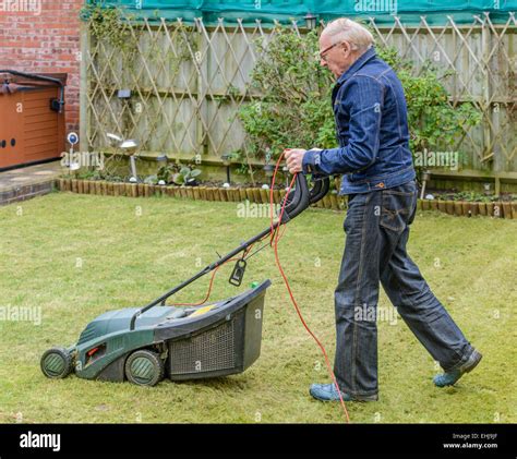 Old Man Mowing The Lawn In A Garden Stock Photo Alamy