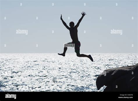 Teenage Boy Jumping Into Ocean Silhouette Stock Photo Alamy